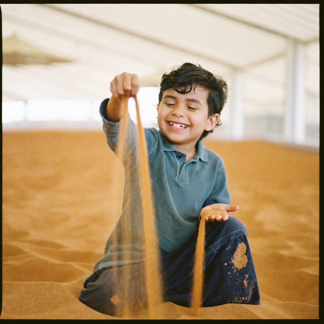 A child playing with desert sand